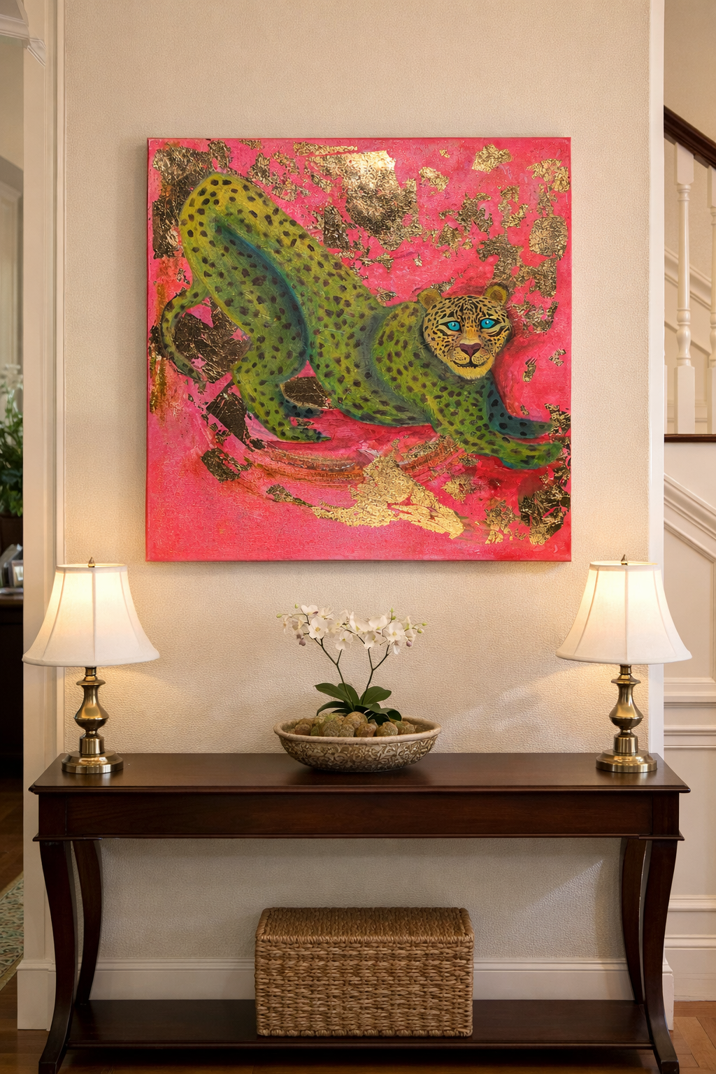 Framed painting of a green spotted leopard on hot pink with gold leaf accents, above an entryway console table